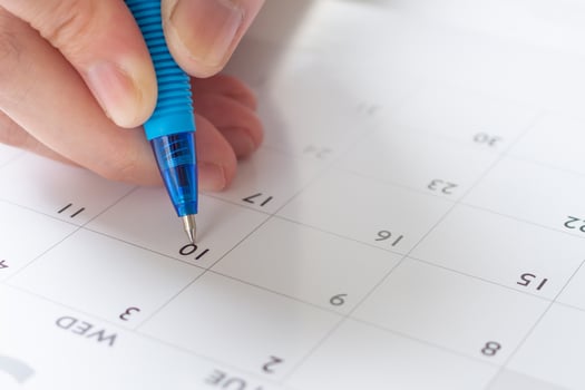 Woman hand with pen writing on calendar date business planning appointment meeting concept photo