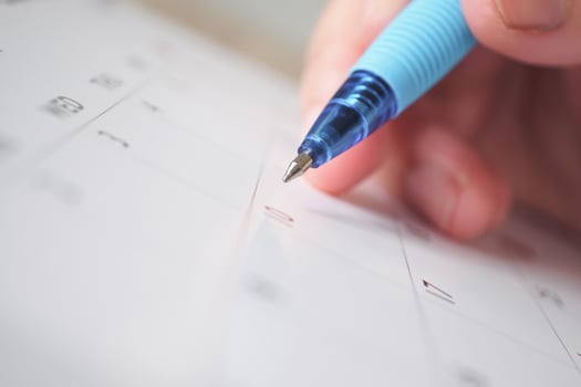 Woman hand with pen writing on calendar date business planning appointment meeting concept photo
