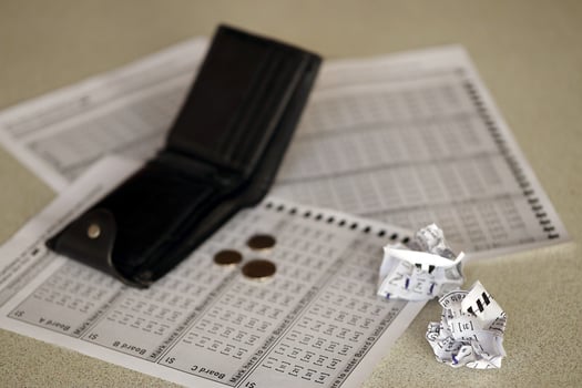 Crumpled lottery tickets and empty purse as symbol of losing the lottery game. Unlucky gambling results. Misfortune photo