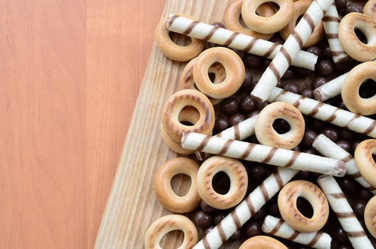 Crispy tubules, chocolate melting balls and bagels lie on a wooden surface. Mix of various sweets photo