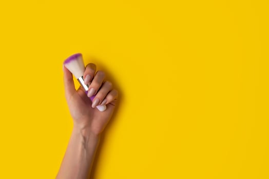 Female hands with a beautiful manicure on a yellow background,top view photo