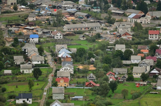A beautiful view of the village of Mezhgorye, Carpathian region. A lot of residential buildings surrounded by high forest mountains and long river photo