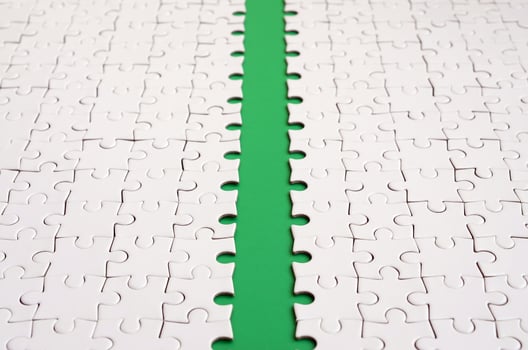 The green path is laid on the platform of a white folded jigsaw puzzle. Texture image with copy space for text photo
