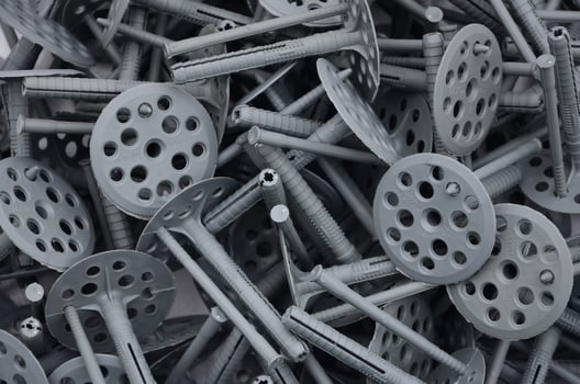 Background pattern of many gray plastic dowels fastening for thermal insulation. A huge pile of fixtures for the installation of expanded polystyrene plates for the insulation of the building walls photo