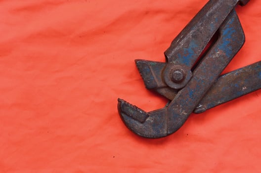 Adjustable wrench against the background of an orange signal worker shirt photo