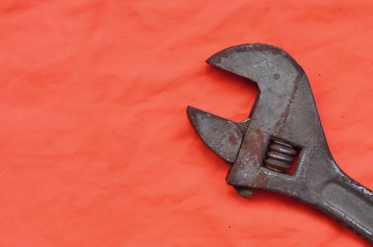 Adjustable wrench against the background of an orange signal worker shirt photo