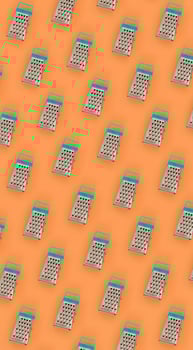 Small stainless steel graters lies on a pastel colored paper. Kitchen accessories. Tools for cooking. Flat lay top view photo
