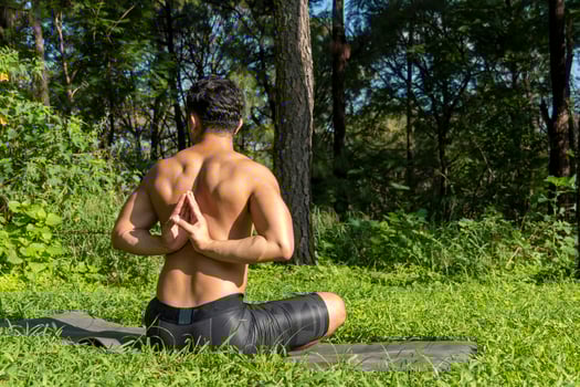 latin american man doing yoga posture, yoga posture, Bee backwards Prsthatah Brahmara, forest photo