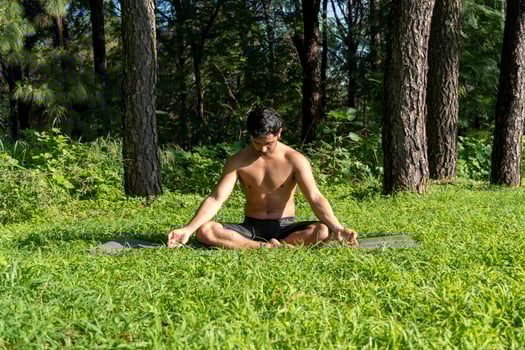 hispanic and latin man, meditating in the middle of a forest, receiving sun rays, brown skin, mexico photo
