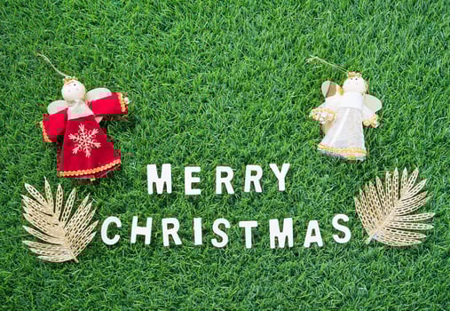 Christmas alphabet and decoration on green grass photo