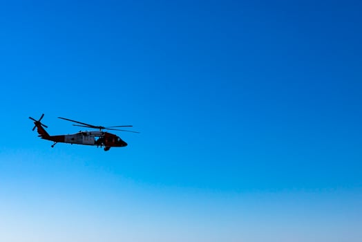 Military American helicopter flies in the blue sky. Military, rescue equipment. photo