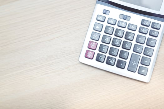 close up calculator focus at on press button keyboard on the wood table office. concept calculate account finance. photo