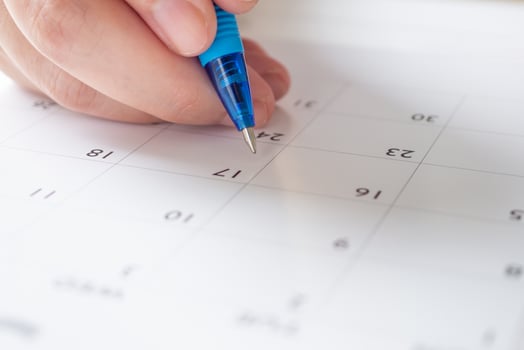 Woman hand with pen writing on calendar date business planning appointment meeting concept photo