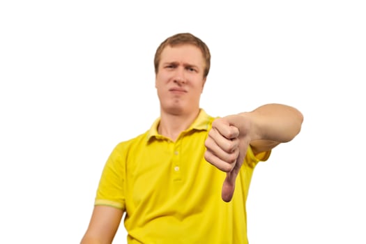 Unhappy annoyed man in yellow T-shirt showing thumbs down gesture isolated on white background photo