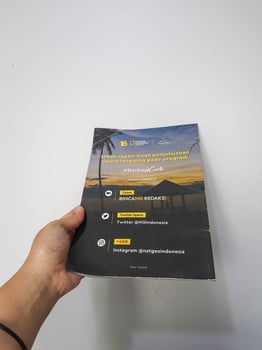 West Java in August 2022. A hand holds the Indonesian version of the National Geographic magazine. photo