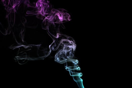 Multicolored smoke for aromatherapy relaxation on black background, beautiful swirled puffs of smoke photo