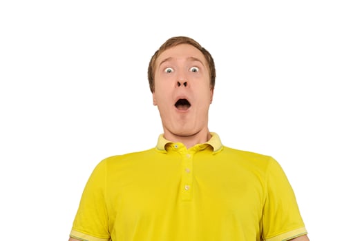 Surprised young male with funny face with wide open mouth in yellow T-shirt isolated on white photo