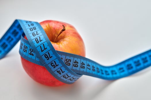 Red apple with measuring tape isolated on white background photo