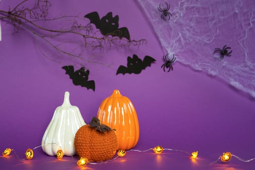 Halloween backgrounds of white, orange and gold pumpkins, spiders and black bats on a purple background with cobwebs and terrible scenery. Horror and a scary holiday with copy space photo