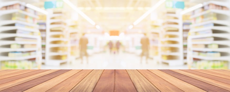 Wood table top with supermarket grocery store aisle interior blurred background with bokeh light for product display photo