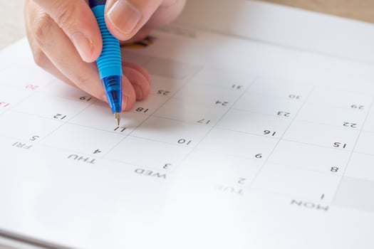 Woman hand with pen writing on calendar date business planning appointment meeting concept photo