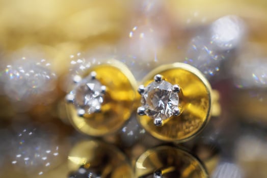 Luxury gold Jewelry diamond earrings with reflection on black background photo