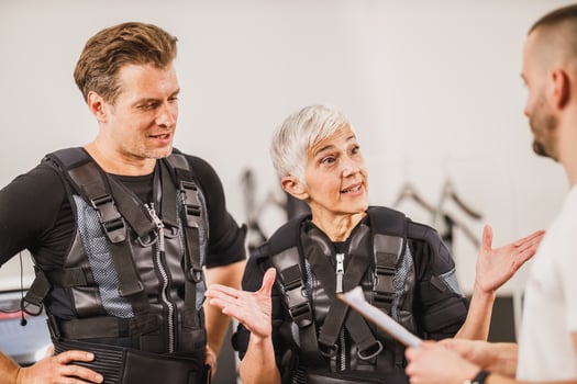 Couple Talking With Coach before EMS Training photo