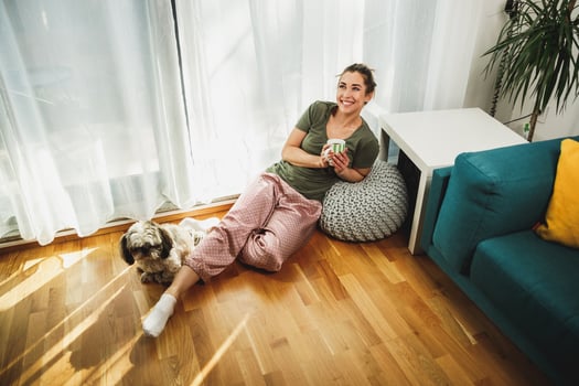 Woman Enjoying Coffee At Morning Sunshine With Her Small Dog photo