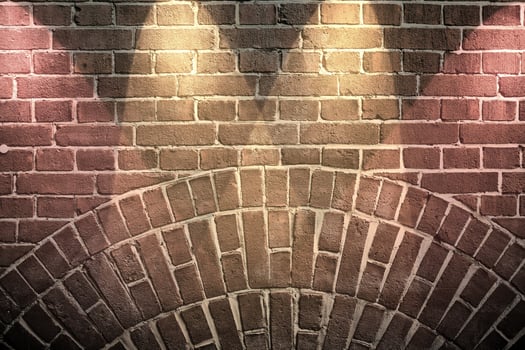 Aged and weathered brick wall textures with very bright spotlight illumination photo