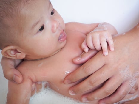 Asian Newborn baby girl bathing with mother photo