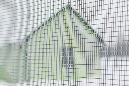 Fence net in winter. Fence around house. House out of town. photo