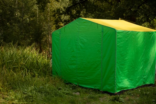 Green tent in forest. Tent for trade in park. Green awning in nature. photo