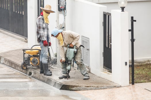 Construction worker using jackhammer drilling concrete surface photo
