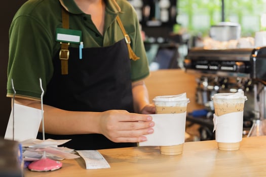 Barista serving ice coffee to customer in cafe coffee shop. photo