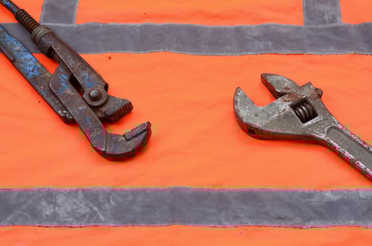 Adjustable and pipe wrenches against the background of an orange photo