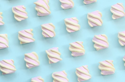 Colorful marshmallow laid out on blue paper background. pastel creative textured pattern. minimal photo