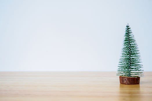christmas tree on wood table with white wall background photo