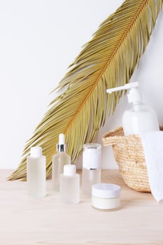 Spa treatment with natural skin care products, towel and basket on white background. Close up. photo