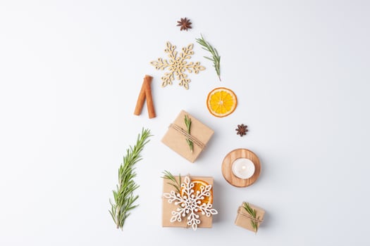 Christmas tree shape made with gifts in craft paper and Christmas decorations on white background. Flat lay, copy space photo