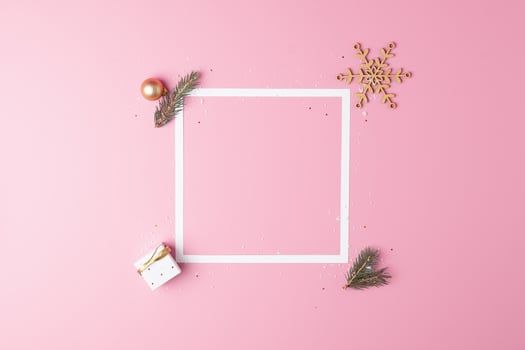 Christmas decorations with white frame and gift on pink background. Flat lay, copy space photo