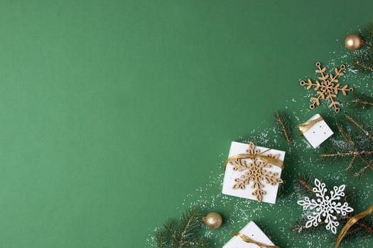 Christmas decorations with packaging gifts and Christmas tree on green background. Flat lay, copy space photo