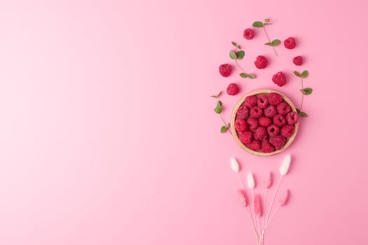 Creative summer background made from fresh berries and flowers on pink. Flat lay, copy space. photo