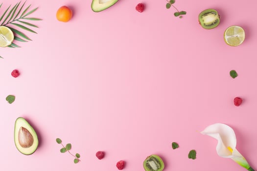 Creative tropical background made from fresh fruits and palm leaves on pink. Flat lay, copy space. photo