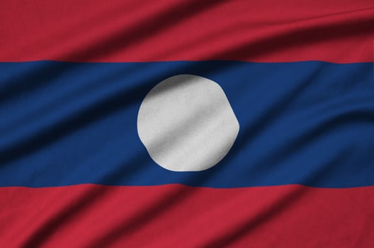 Laos flag  is depicted on a sports cloth fabric with many folds. Sport team banner photo
