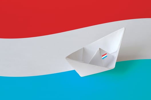 Luxembourg flag depicted on paper origami ship closeup. Handmade arts concept photo