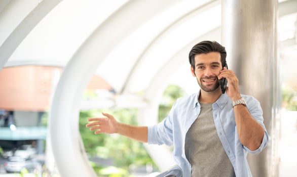 The young man using a smartphone to talk with his friend at the outdoor. The man wearing casual cloth and feeling happy and relaxing. photo