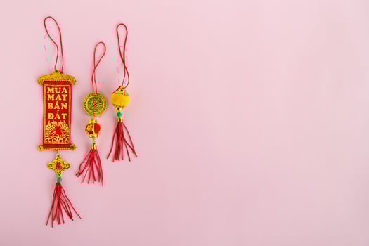 Traditional Vietnamese and Chinese New Year decorations red and golden colors on a pink background, top view. photo