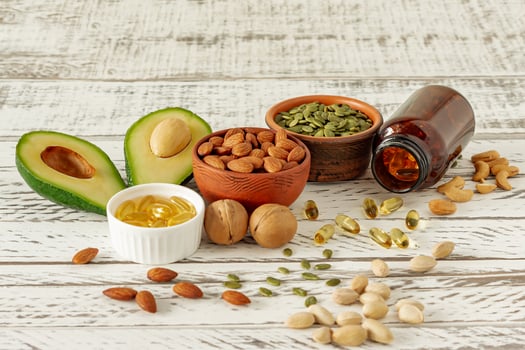 vegetable sources of omega-3 acids. Balanced diet concept. Avocado, nuts, oils on wooden background photo