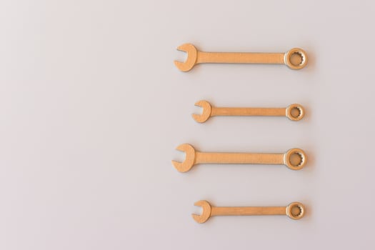 New wrenches on grey background, top view with space for text. professional plumber tools with fixing bolts. photo