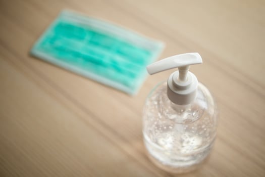 Medical face mask with alcohol sanitizer gel hand wash on wood table for covid-19 Coronavirus prevention concept photo